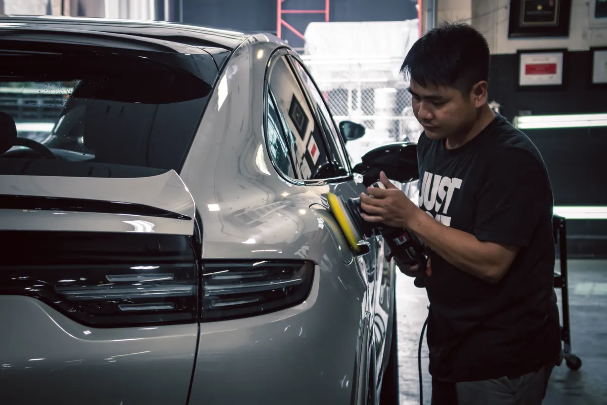 Elements Labs technician machine-polishing the rear quarter of a silver vehicle
