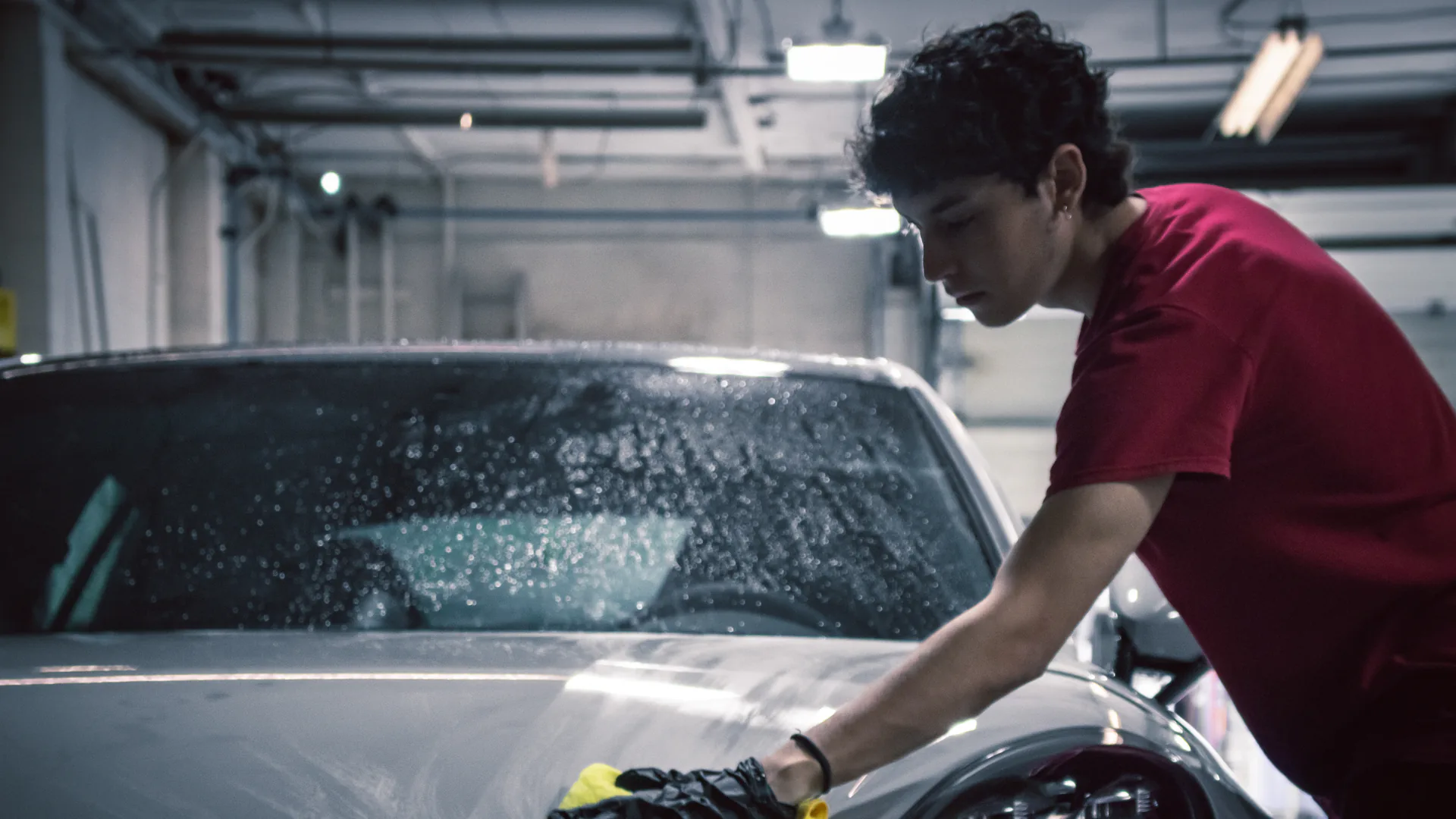 Elements Labs technician hand washing a Porsche in the Vancouver workshop