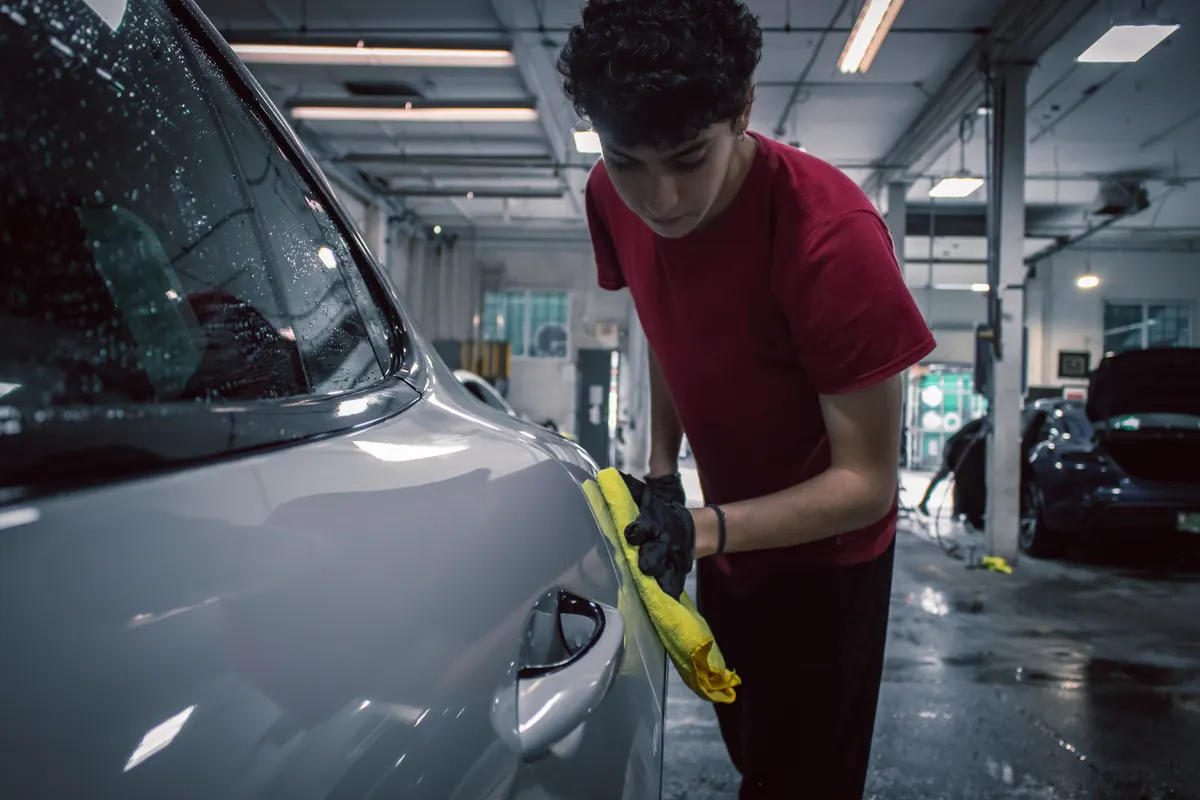 Elements Labs technician hand-finishing a silver vehicle after workshop preparation