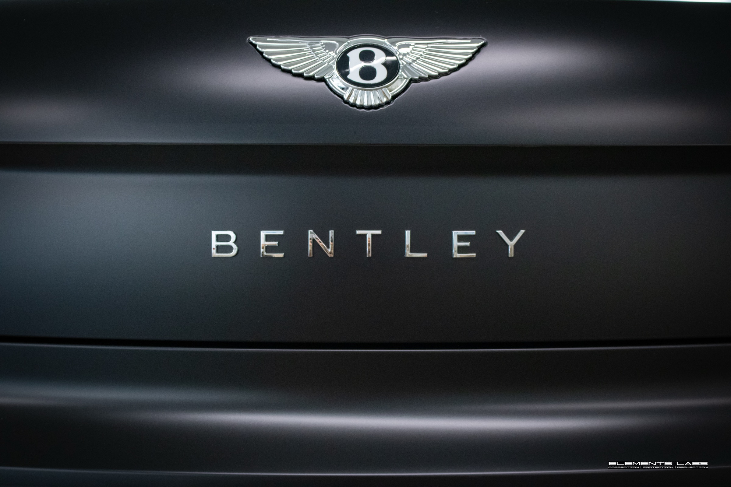 Bentley badge detail on a matte/satin PPF finish