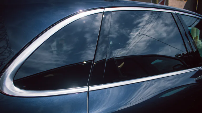 Close view of tinted side windows on a blue vehicle.